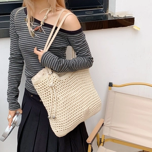 Close-up of cream crochet beach tote bag with hollow mesh design and shoulder strap