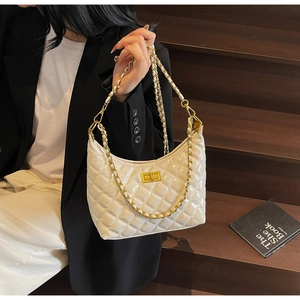 Close-up of quilted white patent leather handbag with gold twist lock and chain strap
