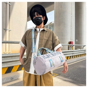 Waterproof grey gym bag with SJCHAO lettering and patterned straps shown in street setting