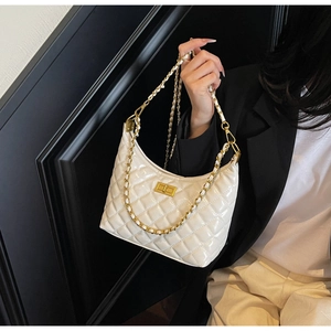 Detailed view of white quilted faux leather hobo bag with gold chain strap and metal lock