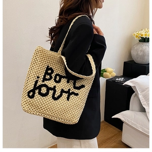 Détail du sac cabas tissé beige avec lettrage Bon jour brodé noir pour les vacances