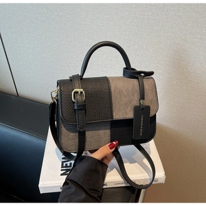 Detail of color-block PU leather bag with woven texture, round handle and gold hardware