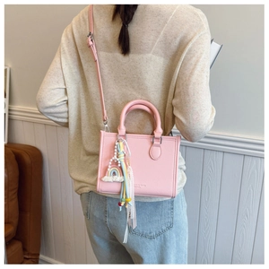 Detailed macro of pink lychee leather tote with J&M LOVE logo and rainbow charm