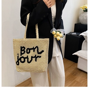 Détail de la texture en paille tressée avec broderie Bonjour sur le sac fourre-tout