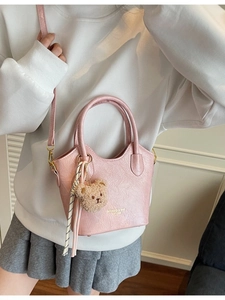 Borsa a secchiello vintage rosa con ciondolo a orsetto e foulard, indossata a spalla