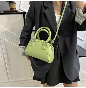 Détail du sac bowling vert avocat avec fermetures argentées et lettrage fashion bags