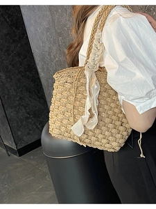Woven straw bucket bag with pearl details and a silk scarf for a French holiday style