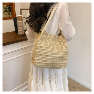 Detail shot of the handwoven texture and structure of the beige straw tote bag