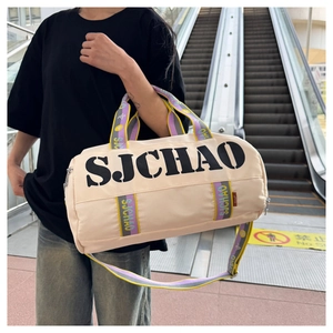 Detail of trendy beige duffel bag featuring vibrant purple and yellow contrast straps