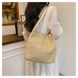 Detail of woven straw tote bag texture and its casual fit on a model shoulder