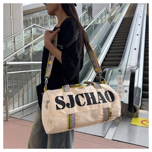 Macro shot of cream nylon gym bag with SJCHAO lettering and woven straps on model