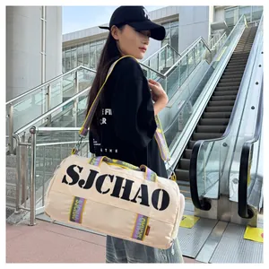 Cream medium cylinder travel bag featuring colorful striped strap and black SJCHAO text