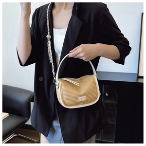 Detail of beige straw bag with white leather trim and metallic adjustable ball chain
