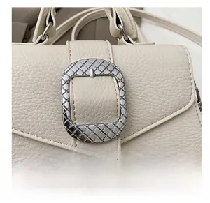Detail von Leder mit Lychee-Muster und silberner Metallschnalle an einer Retro-Handtasche