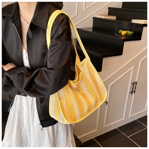 Model showing a large yellow and white striped mesh tote bag for summer beach or casual use
