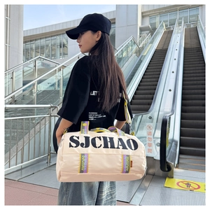 Close-up of beige canvas travel bag with SJCHAO logo and striped handles on a shoulder strap