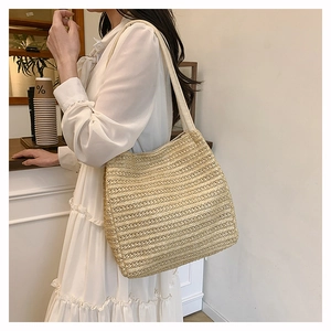 Detail of hand-woven straw tote bag with fabric shoulder strap for summer vacation