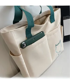 Detail of canvas tote bag with front pocket showing large capacity for smartphone storage
