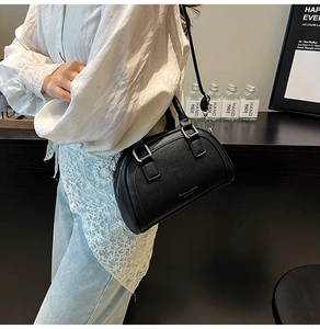Détail d'un sac à main noir en cuir grainé avec finitions argentées et bandoulière chic