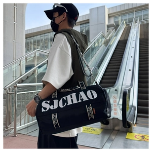 Close-up of black canvas travel bag with SJCHAO lettering and woven strap details