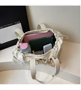 Top view of spacious cream tote bag interior filled with laptop, tablet, and water bottle