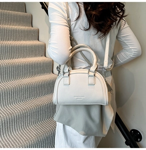 Détail du sac bowling en cuir grainé blanc avec logo embossé et finitions argentées