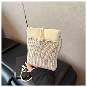 Detail of woven straw crossbody bag with cream leather flap and pearl button closure