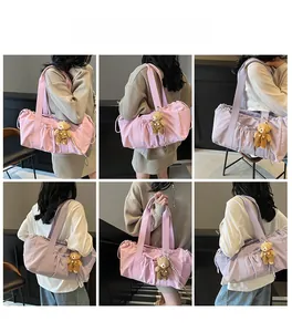 Multi-angle view of pink nylon cylinder bag with drawstring pockets and bear charm
