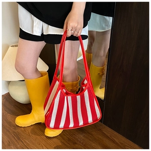 Detail of red and white striped mesh tote bag with reinforced red leather handles