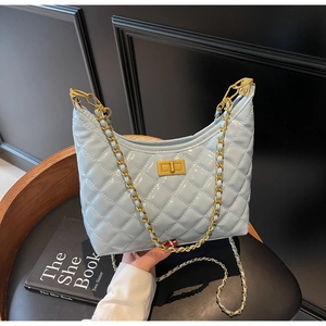 Detail of light blue quilted chain bag with gold twist lock and glossy finish texture
