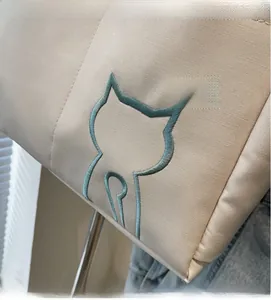 Detailed blue cat embroidery on beige canvas tote bag with precise stitching