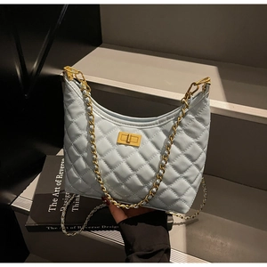 Close-up of light blue quilted leather handbag with gold chain strap and metal turn-lock