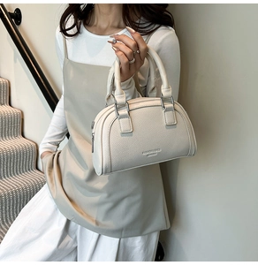Détail du sac Boston en cuir grainé blanc avec finitions argentées et texte embossé