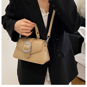Detail der hellbraunen Ledertasche mit silberner Metallschnalle und verstellbarem Schultergurt