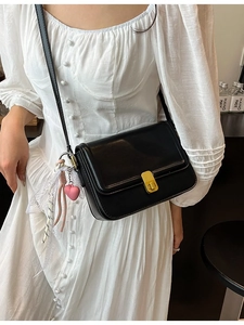 Elegant black leather crossbody bag with golden clasp and heart charm for women