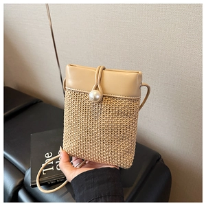 Detail of hand-woven crossbody bag with elegant pearl clasp and slim leather strap
