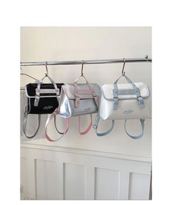 Three colors of retro British style faux leather backpacks hanging on a metal rack