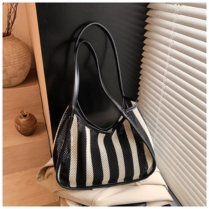 Artistic shadow play on a striped mesh tote bag placed over neutral linen fabrics