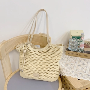Detail of crochet woven tote bag with faux leather strap on wooden chair setup