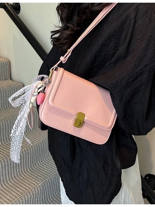 Pink square crossbody bag for women with gold lock and lace bow charm on model