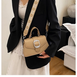 Detail der hellbraunen Ledertasche mit breitem, geometrisch besticktem Schultergurt