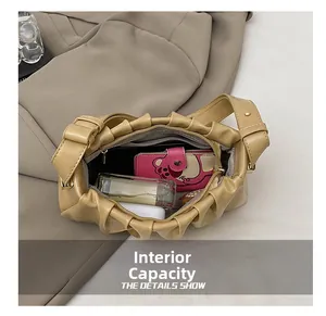 Internal capacity view of beige pleated cloud bag with pink wallet and cosmetics