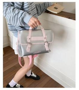 Detail view of silver PU backpack with pink straps and metallic buckles for daily commute