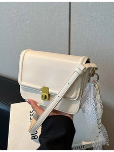 Chic beige crossbody bag with gold twist lock and elegant lace scarf decoration