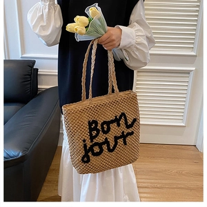 Détail du sac cabas en paille tissée avec broderie Bon jour noire pour l'été