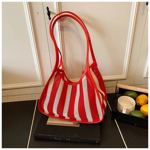 Detail of red and white striped mesh tote bag with leather handles for travel and leisure