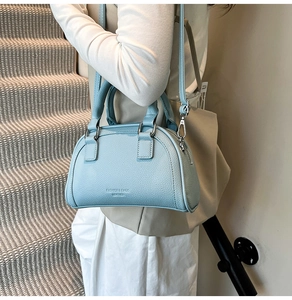 Détail du sac Boston en cuir bleu clair avec fermeture éclair et bandoulière amovible