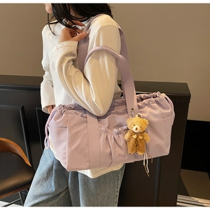 Detail of lilac canvas tote bag featuring drawstring closure and cute plush bear charm