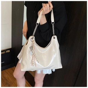 Detail of cream white Hobo bag with silver chain and tennis racket pendant accessory