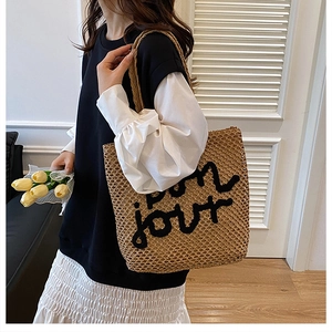 Détail du sac cabas en paille tissée avec lettrage bon jour noir brodé sur le devant